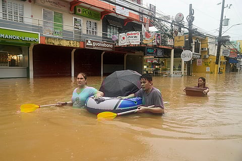 Philippines Tropical Storm Yagi: Residents use rubber paddles from a toy boat